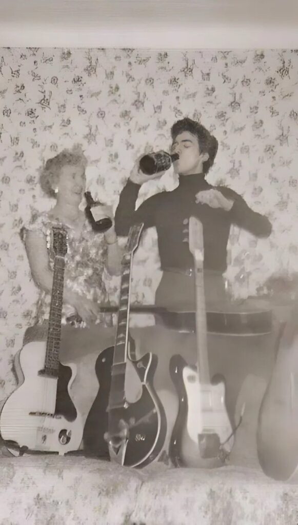 ギターを前に母親と酒を交わすGeorge